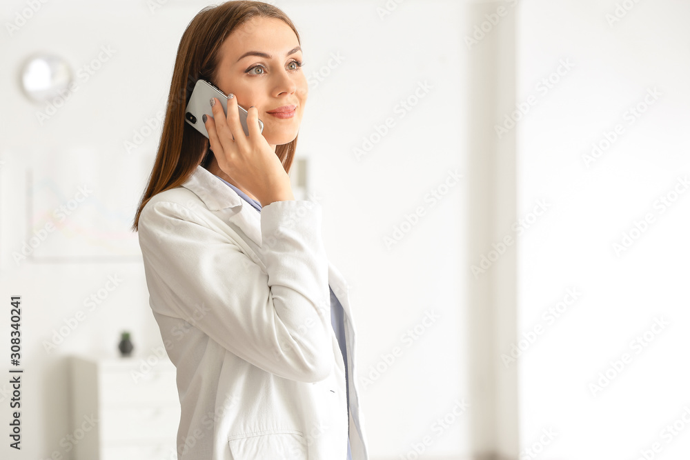 Beautiful young businesswoman talking by mobile phone in office Beautiful young businesswoman talking by mobile phone in office