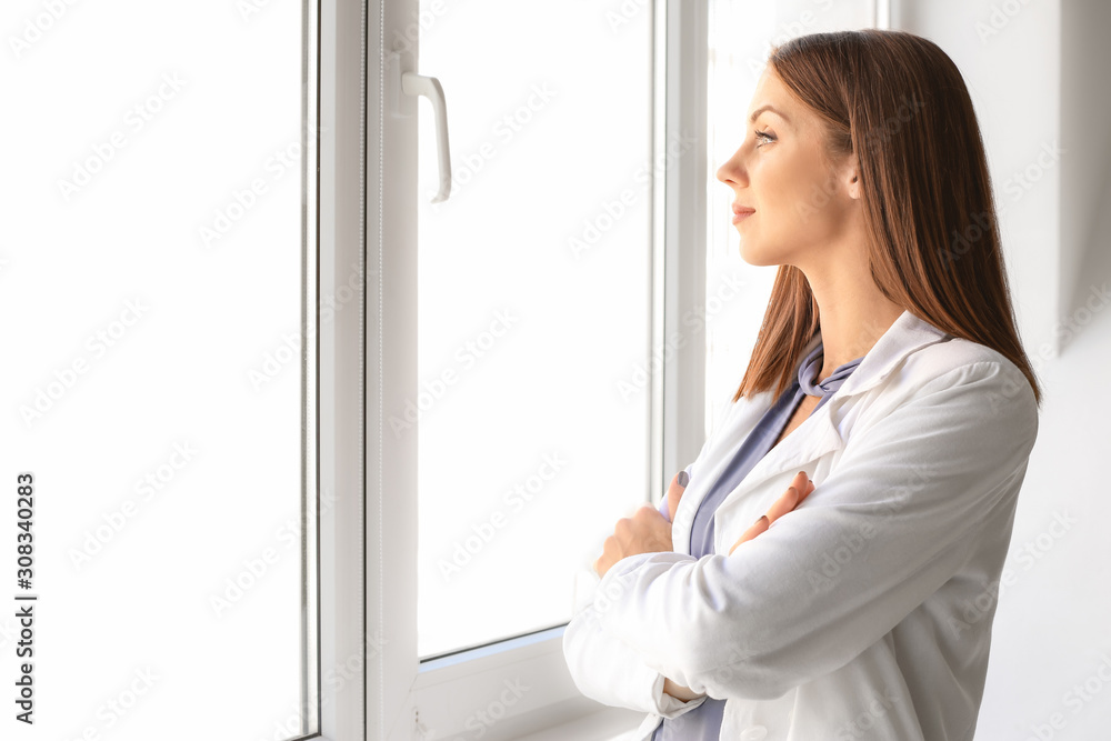 Beautiful young businesswoman near window in office Beautiful young businesswoman near window in office