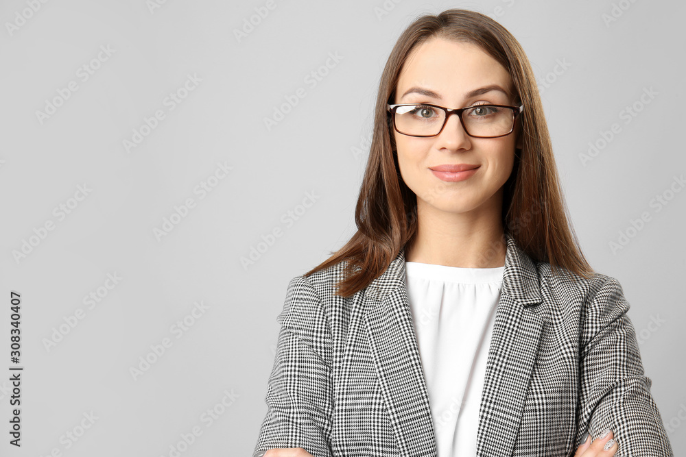 Beautiful young businesswoman on grey background
