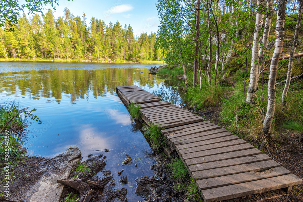 Wooden pontoon in the border of Yattumutka river in Oulanka National Park. Pieni Karhunkierros Trail in Finland. Wooden pontoon in the border of Yattumutka river in Oulanka National Park. Pieni Karhunkierros Trail in Finland.
