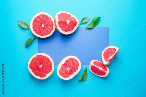 Fresh cut grapefruit and blank card on color background