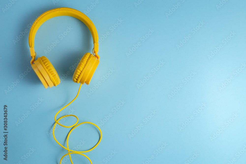 Yellow headphones on blue background. Music concept. Yellow headphones on blue background. Music concept.