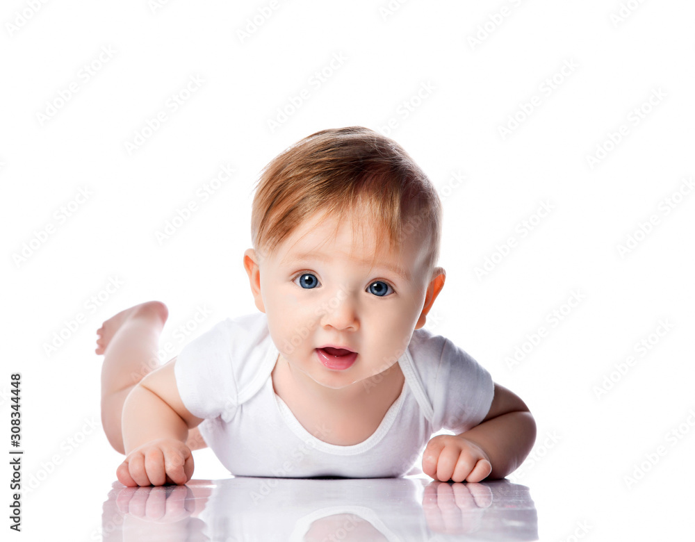 Infant child baby boy kid with blue eyes happy smiling screaming lying on a floor isolated on a white background Infant child baby boy kid with blue eyes happy smiling screaming lying on a floor isolated on a white background