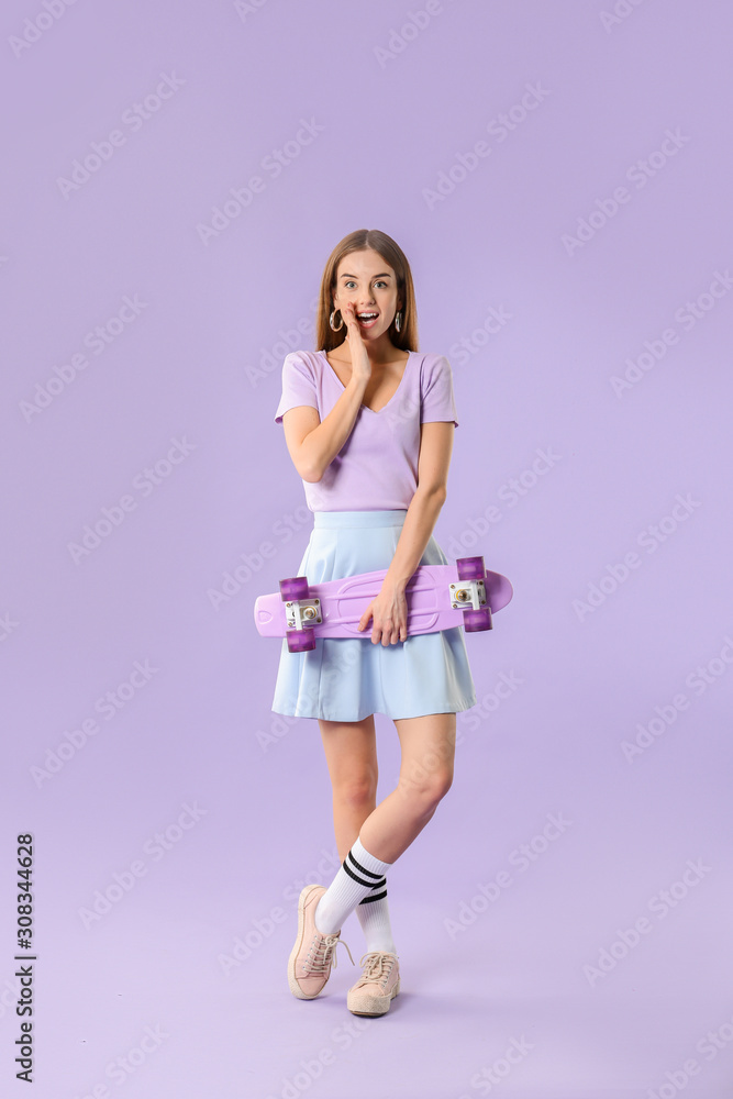 Surprised hipster girl with skateboard on color background Surprised hipster girl with skateboard on color background