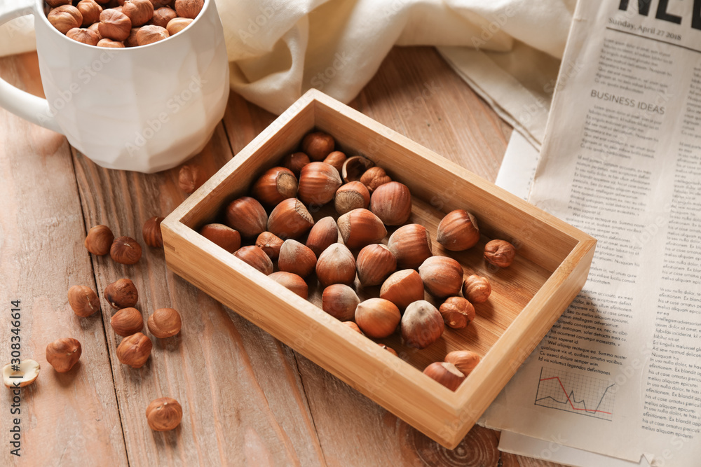 Box with tasty hazelnuts on wooden background Box with tasty hazelnuts on wooden background