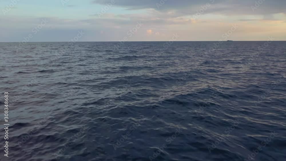 Aerial, tilt up, drone shot, panning over a dark midnight blue sea, on the Indian ocean, on a partly sunny evening, in the Maldives islands Aerial, tilt up, drone shot, panning over a dark midnight blue sea, on the Indian ocean, on a partly sunny evening, in the Maldives islands
