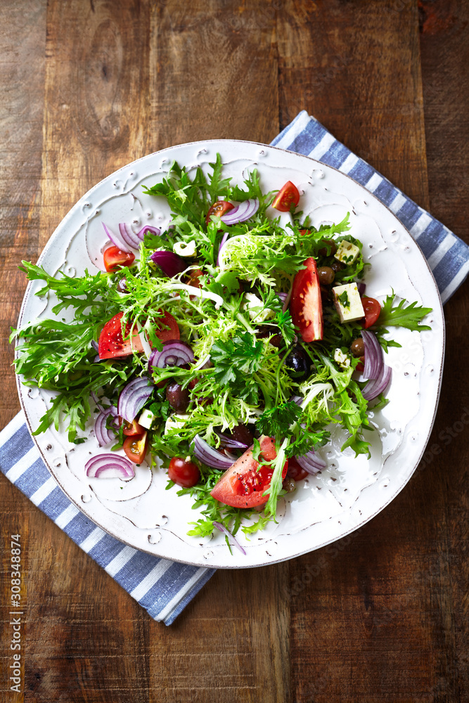 Salad with Olives, Tomatoes, Endive and Red Onion. Healthy Snack Idea. Rustic wooden background. Top view. Salad with Olives, Tomatoes, Endive and Red Onion. Healthy Snack Idea. Rustic wooden background. Top view.
