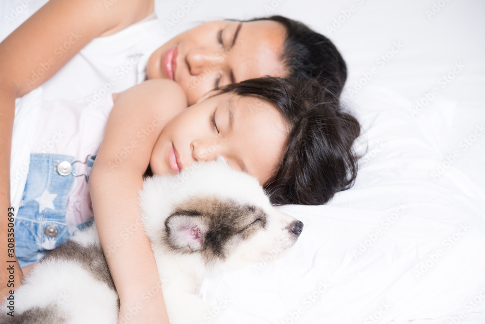 Mother and daughter sleep with her dog.