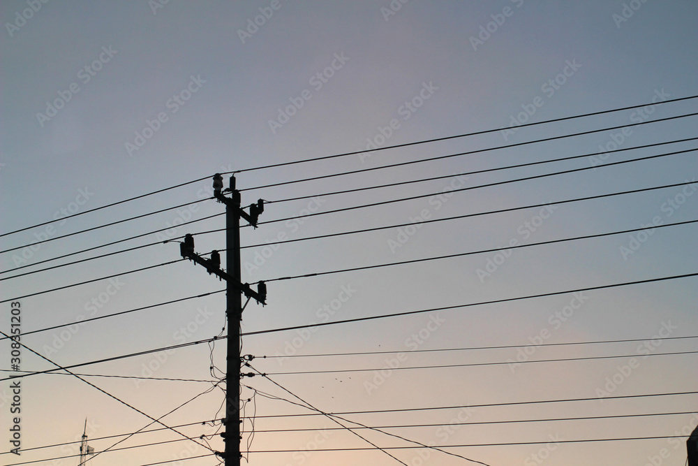 Utility pole supporting overhead power line cables against blue sky as copy space Utility pole supporting overhead power line cables against blue sky as copy space