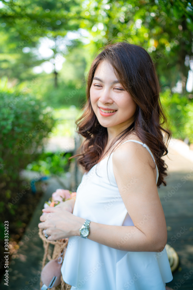 Beautiful wellness asian women walking in city park with white dress Beautiful wellness asian women walking in city park with white dress