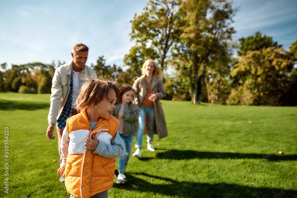 Having fun. Excited family running outdoors on a sunny day Having fun. Excited family running outdoors on a sunny day