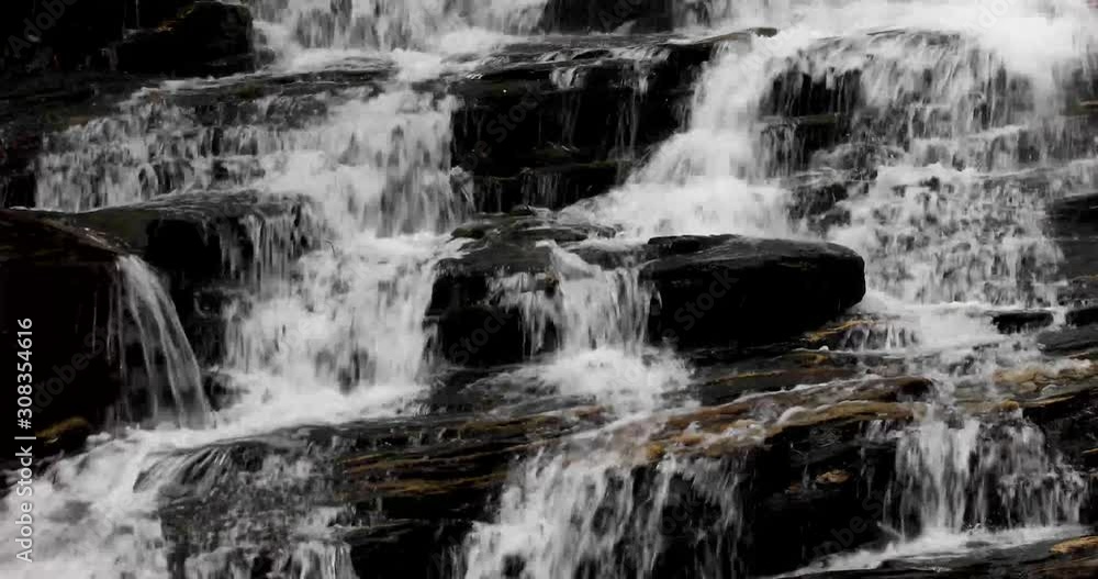 Water splashes and cascades down the rocks of a beautiful waterfall in this seamless video loop Water splashes and cascades down the rocks of a beautiful waterfall in this seamless video loop