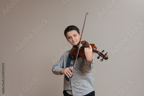Boy playing viola wearing shirt and tie photo