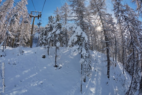 Skiing lift ascend in the Alps with snowy trees in Les Arres, France