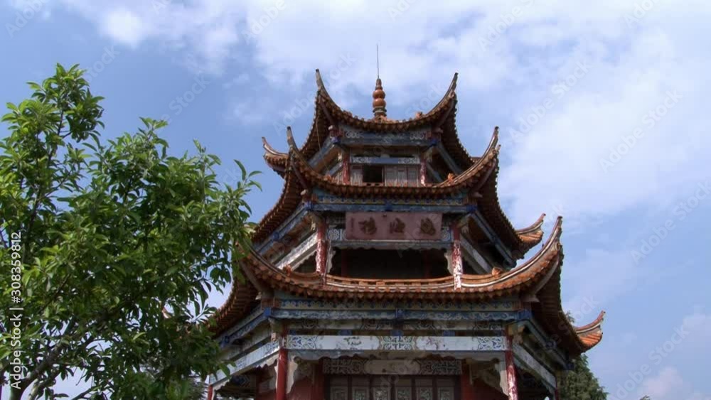 Roof gazebo in Chinese style on coast of Fuxian Lake in Yunnan Province China. Unique mountain lake in East Asia. Landscape on background of sky with gray clouds and fog. Roof gazebo in Chinese style on coast of Fuxian Lake in Yunnan Province China. Unique mountain lake in East Asia. Landscape on background of sky with gray clouds and fog.