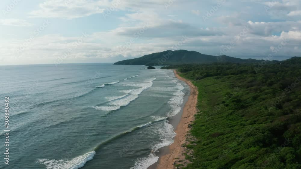 Beautiful 4K aerial drone shot of a tropical Pacific paradise beach at the seaside coast in Costa Rica with giant waves, clounds, nature, jungle and sand. Beautiful 4K aerial drone shot of a tropical Pacific paradise beach at the seaside coast in Costa Rica with giant waves, clounds, nature, jungle and sand.