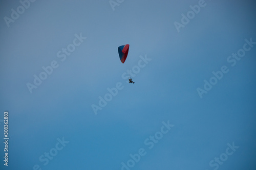 Lonely paraglider in the blue sky. Active rest in summer.