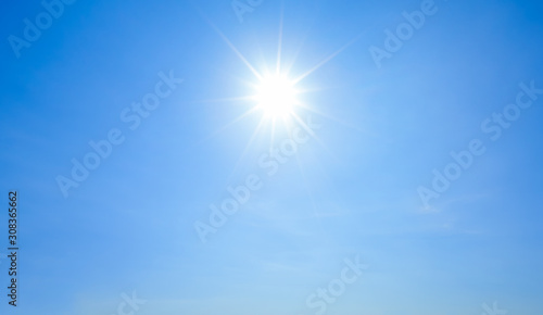 Shining sun with rays and clear blue sky