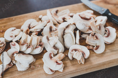 white porcini mushrooms chopped on cutting board with knife