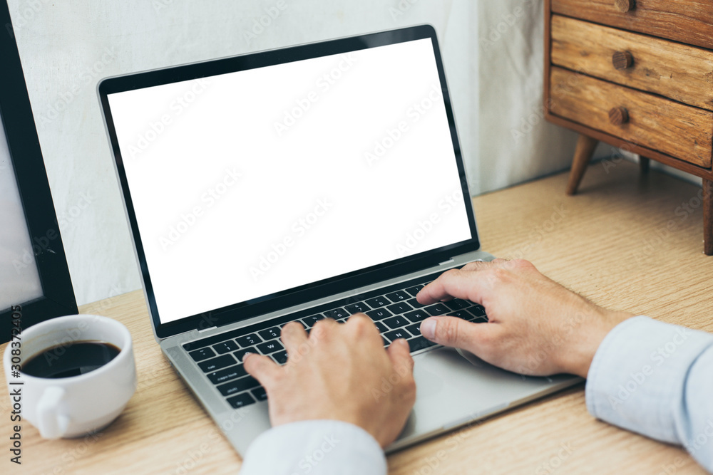 mockup image blank screen computer with blank white background for advertising text,hand man using laptop contact business search information on desk at home office.marketing and creative design mockup image blank screen computer with blank white background for advertising text,hand man using laptop contact business search information on desk at home office.marketing and creative design