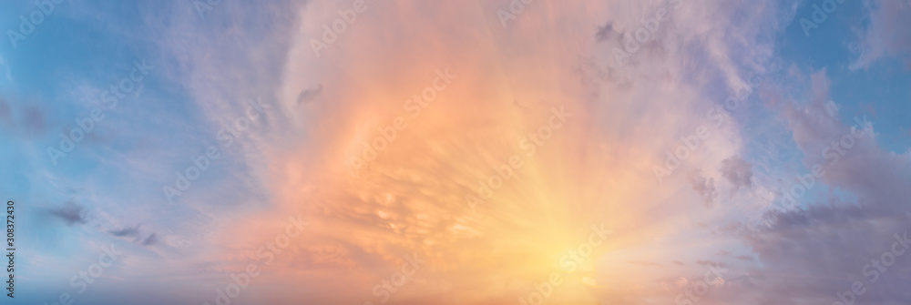 Naklejka premium Sunset cloudy sky with the orange sun