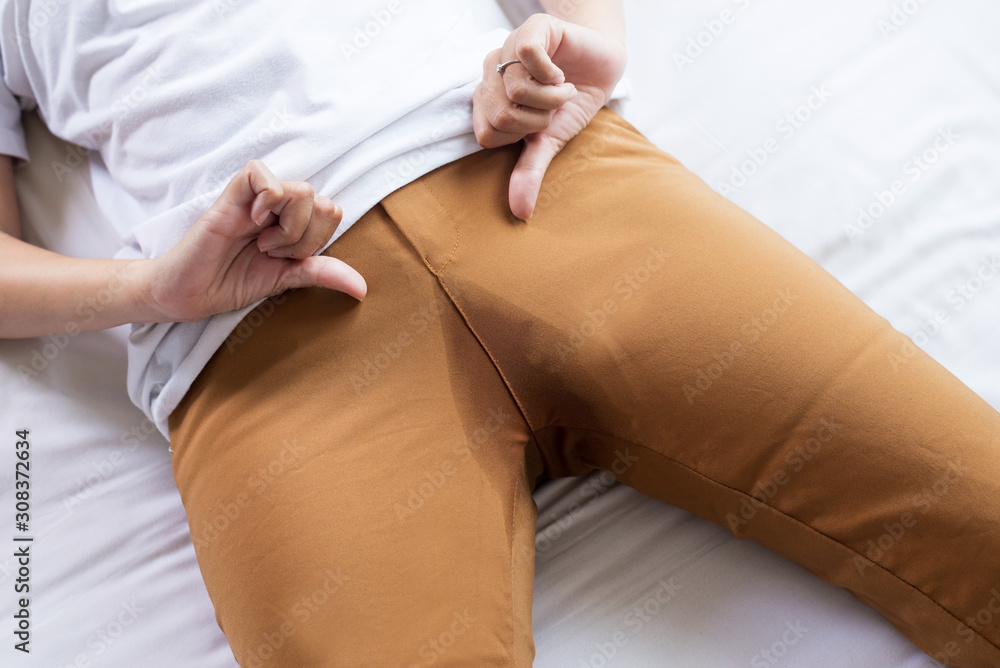 Hands woman holding her crotch and lying on bed,Female need to pee,Urinary  stain incontinence Stock Photo