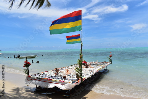Large floating stall to introduce tourists to local crafts. Ingenious system to recycle surf boards and minimize costs. Colored Mauritian flags.