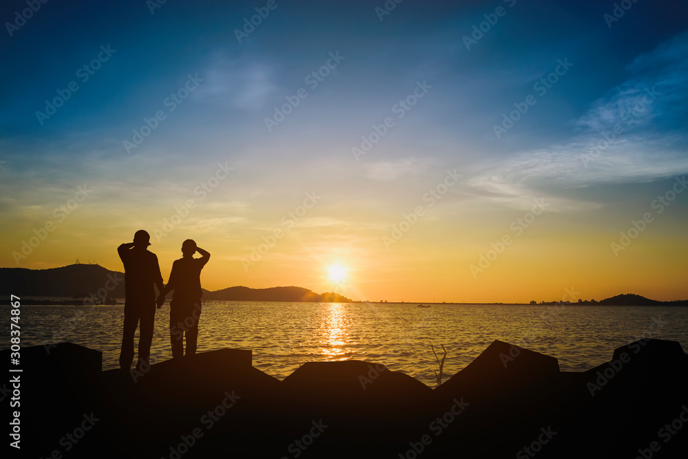 Fototapeta premium Silhouette of a lover watching the sunset in the evening.