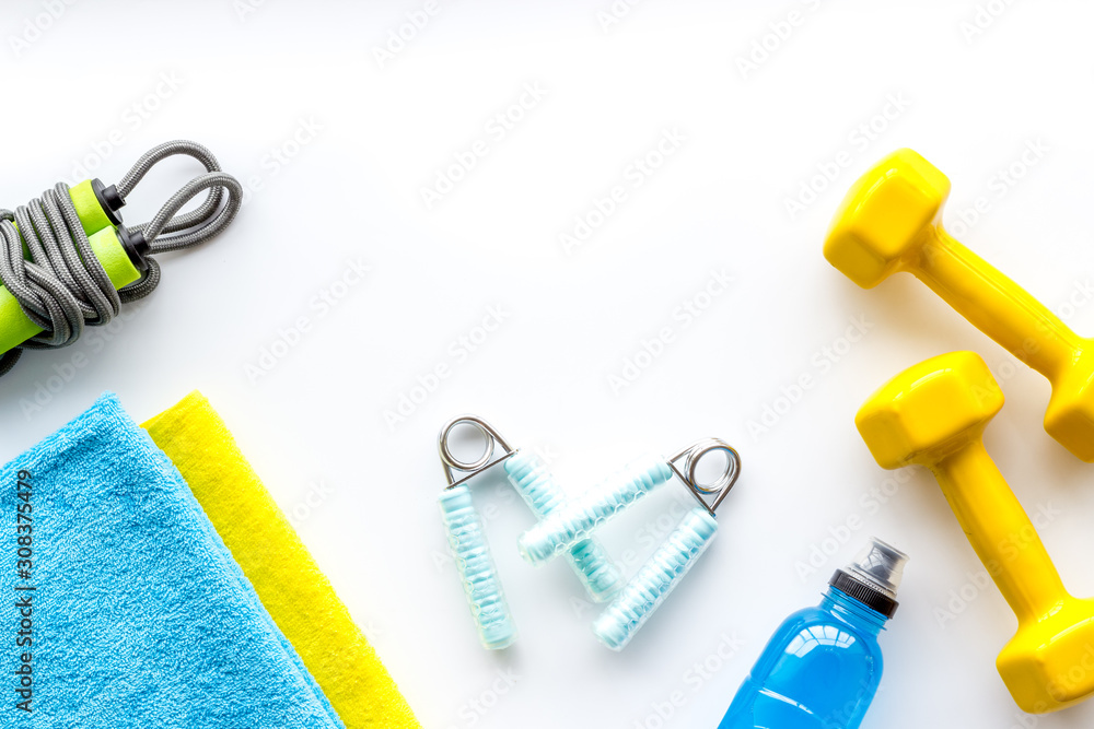 Gym equipment - dumbbells, jump rope - frame on white background top-down copy space Gym equipment - dumbbells, jump rope - frame on white background top-down copy space
