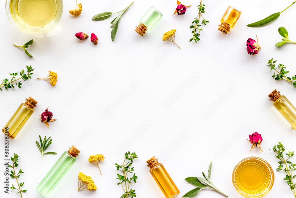 Natural wellness. Essential oils near herbs and leaves on white