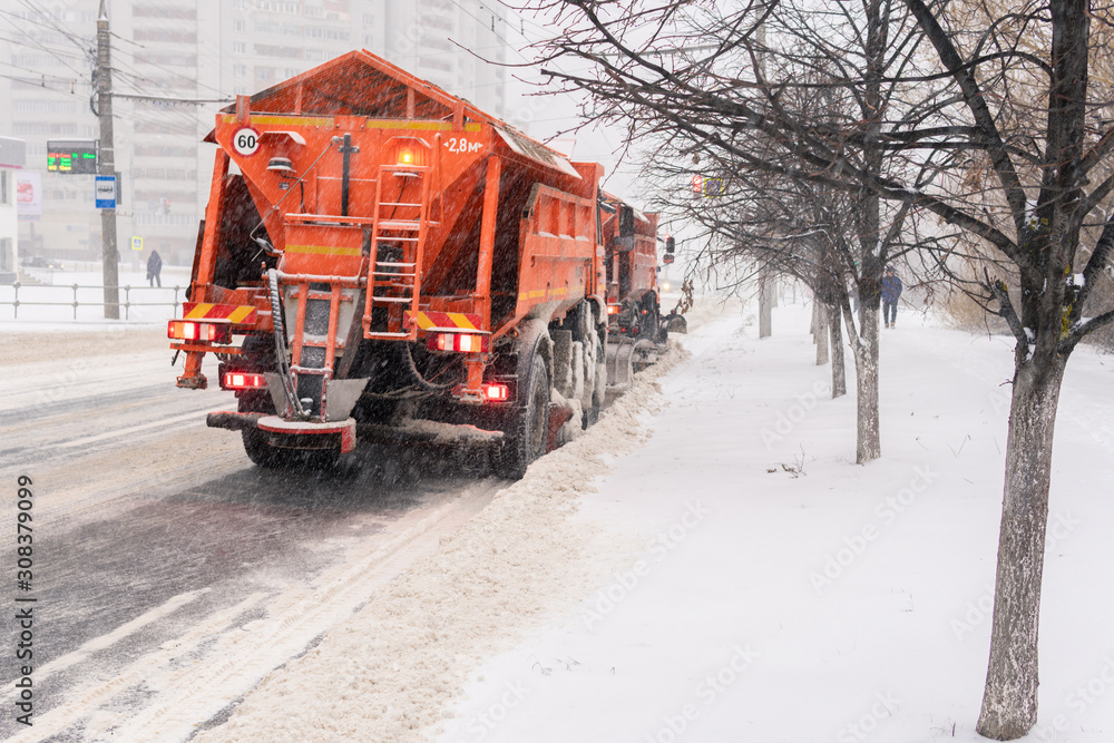 A large snowplow removes snow from the road