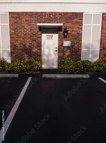 Brick Wall Door Entry Way with a Security Camera Sign photo