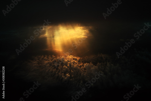 Dramatic god light rays shining from dark cloud on to clouds expanse on the sky. power of hope and god induce strength. light through darkness.