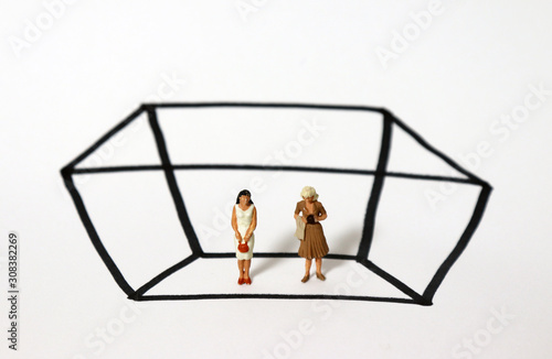 Two miniature woman standing in a rectangle of black solid lines. The concept of the glass ceiling.