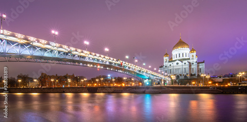 The Cathedral of Christ the Saviour or Savior and Patriarchal pedestrian bridge with night illumination in the evening in Moscow, Russia. Russian Orthodox church on the Moskva river