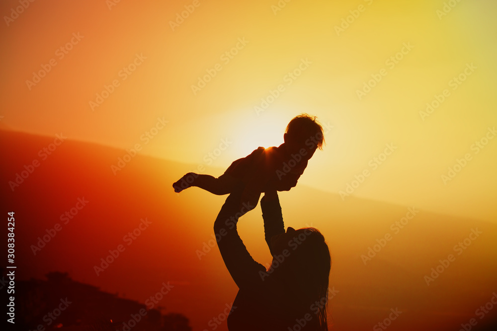 mother and little daughter play at sunset nature