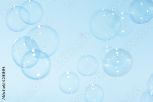 Transparent soap bubbles float in the air on a blue background