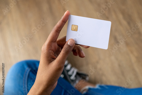 Woman of color holding a blank credit card.