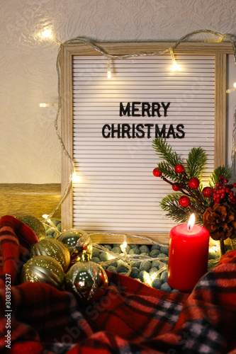  Text board with phrase Merry Christmas  decorated with garland.  photo