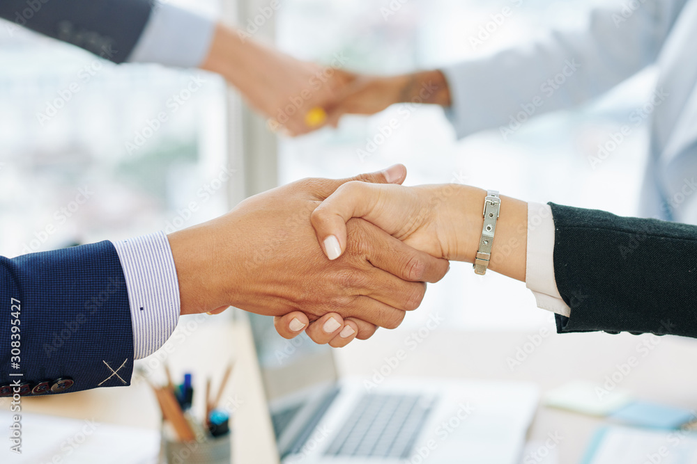 Close-up image of entrepreneurs shaking hands and entroducing themselves before discussing important issues at meeting Close-up image of entrepreneurs shaking hands and entroducing themselves before discussing important issues at meeting