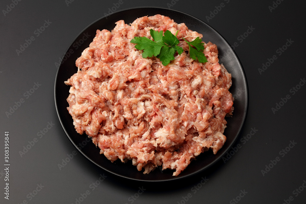Mince. Ground meat with spices on black background. Top view Mince. Ground meat with spices on black background. Top view