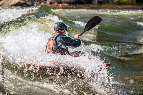 Fototapeta Naklejka Na Ścianę i Meble -  Whitewater kayaking, extreme sport rafting. Guy in kayak sails mountain river