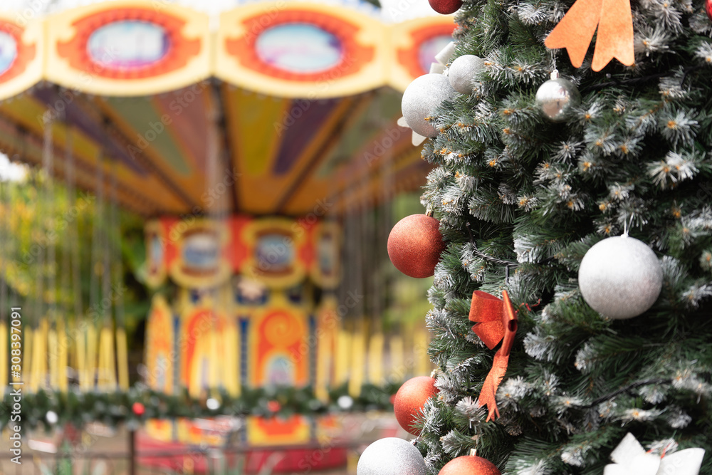 Christmas tree on the background of the carousel in the park