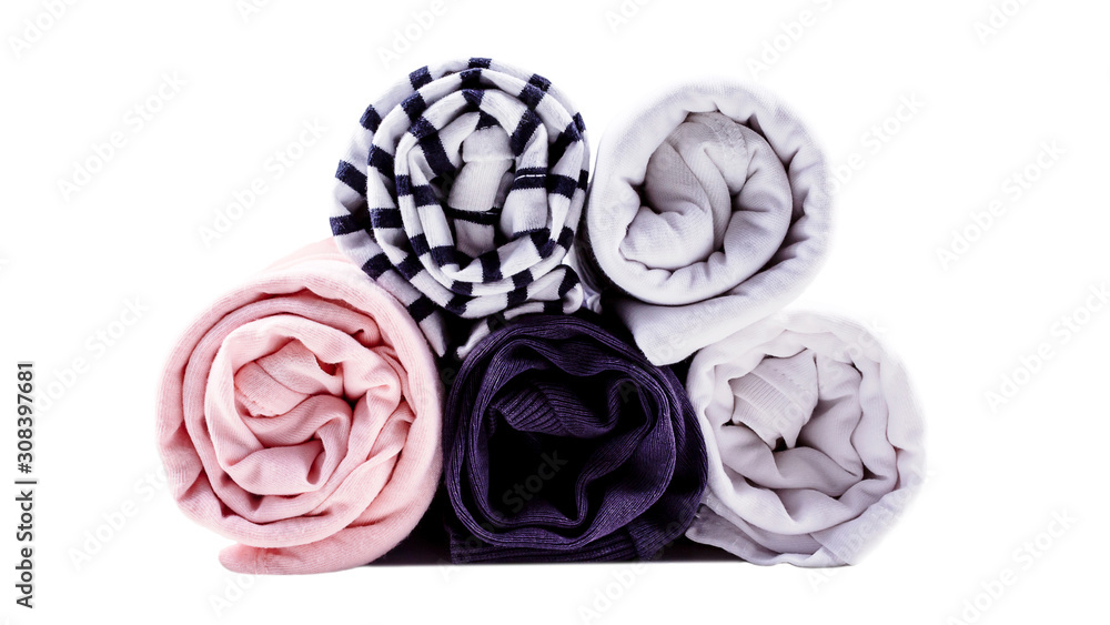 Obraz premium Vertical storage of clothing in rolls. Minimalism color scheme. T-shirts rolled for saving luggage space. Close up. Front view. Isolated on white.
