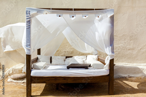 A comfortable canopy bed on the sandy beach photo