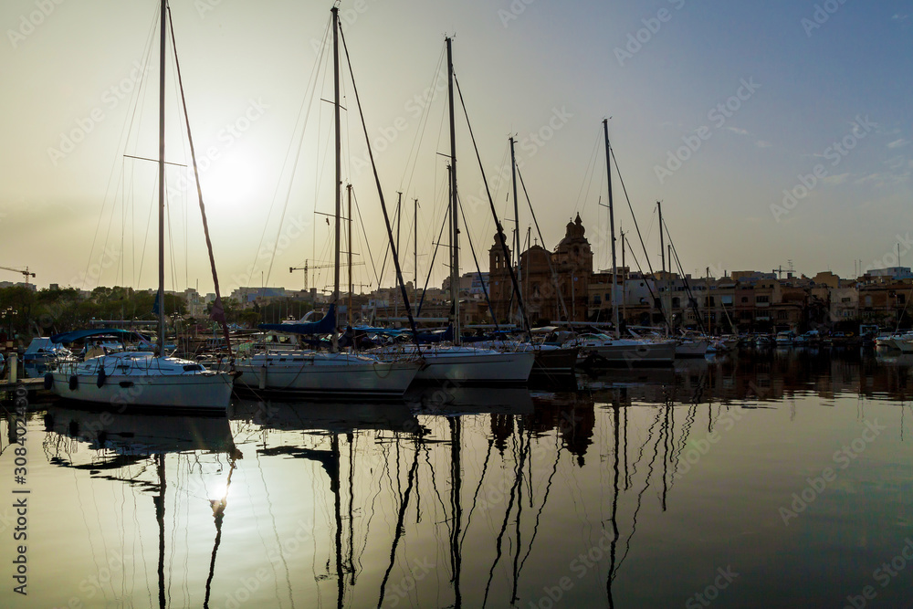 Beautiful sunset with boats moored in the harbor, Malta