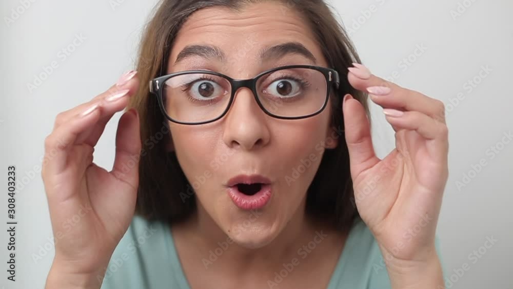 Indian young woman takes off glasses from a shocked look. Emotion of surprise on the girl's face. Indian young woman takes off glasses from a shocked look. Emotion of surprise on the girl's face.