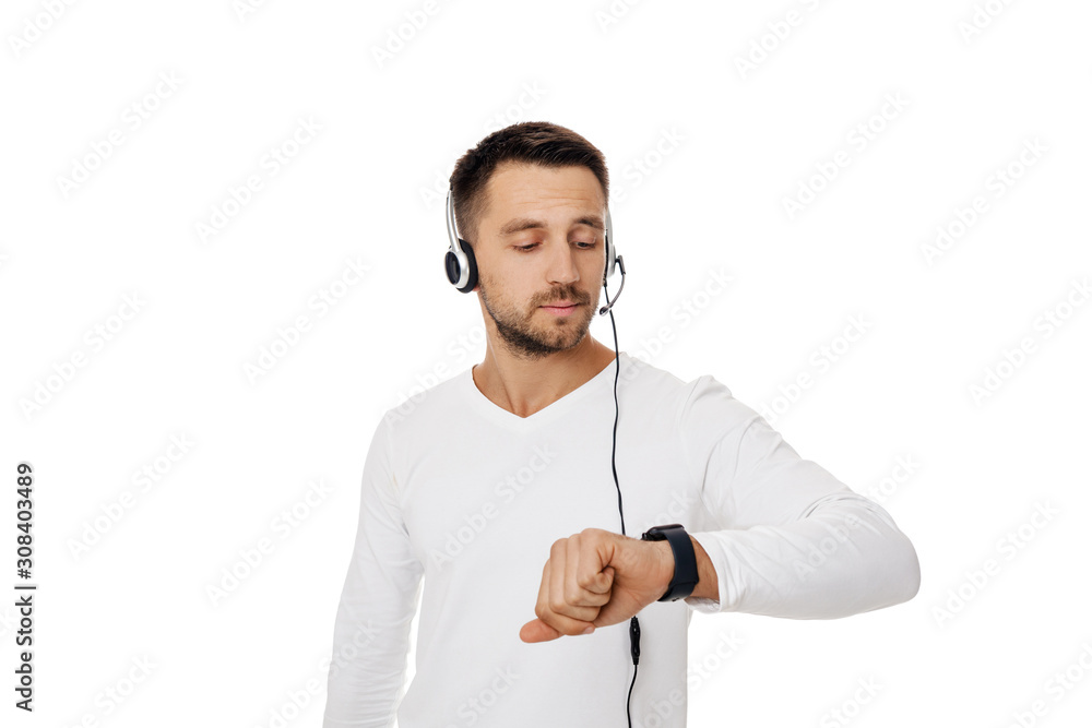 Call center worker man isolated on white background. Young handsome customer service representative using headset and looking at watch Call center worker man isolated on white background. Young handsome customer service representative using headset and looking at watch