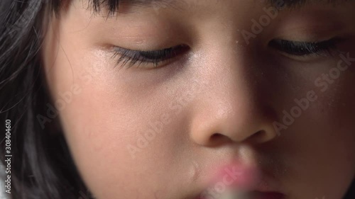 Close up portrait of young Asian girl as she creates art alone isolated indoors