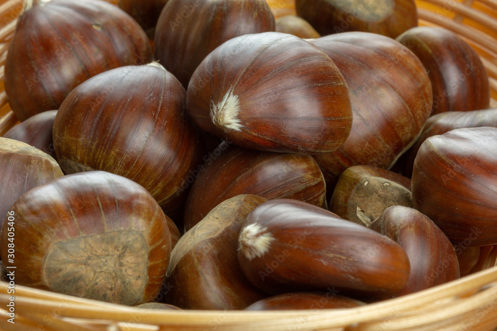 Obraz premium fresh sweet chestnut fruits in a basket closeup